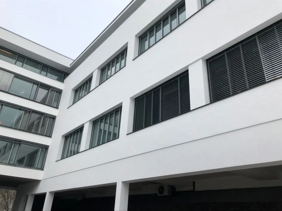 Frisch weiß gestrichene Fassade eines Bürogebäudes mit Fensterbändern.