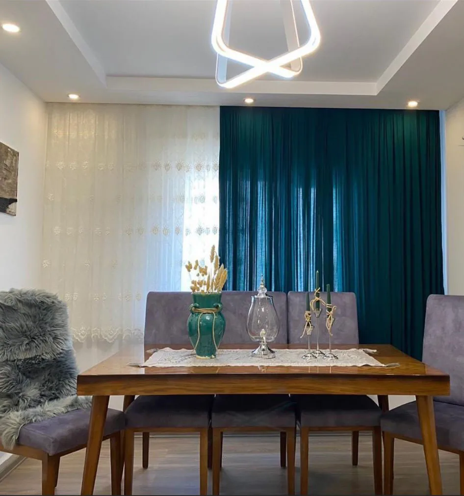 Esszimmer mit abgehängter Lichtdecke, Einbauspots und moderner Ringleuchte.
