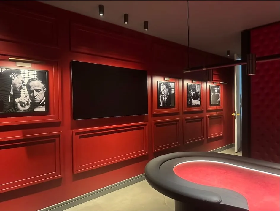 Fertiger Raum mit rot lackierter Kassettenwand, Bildern und Spieltisch.